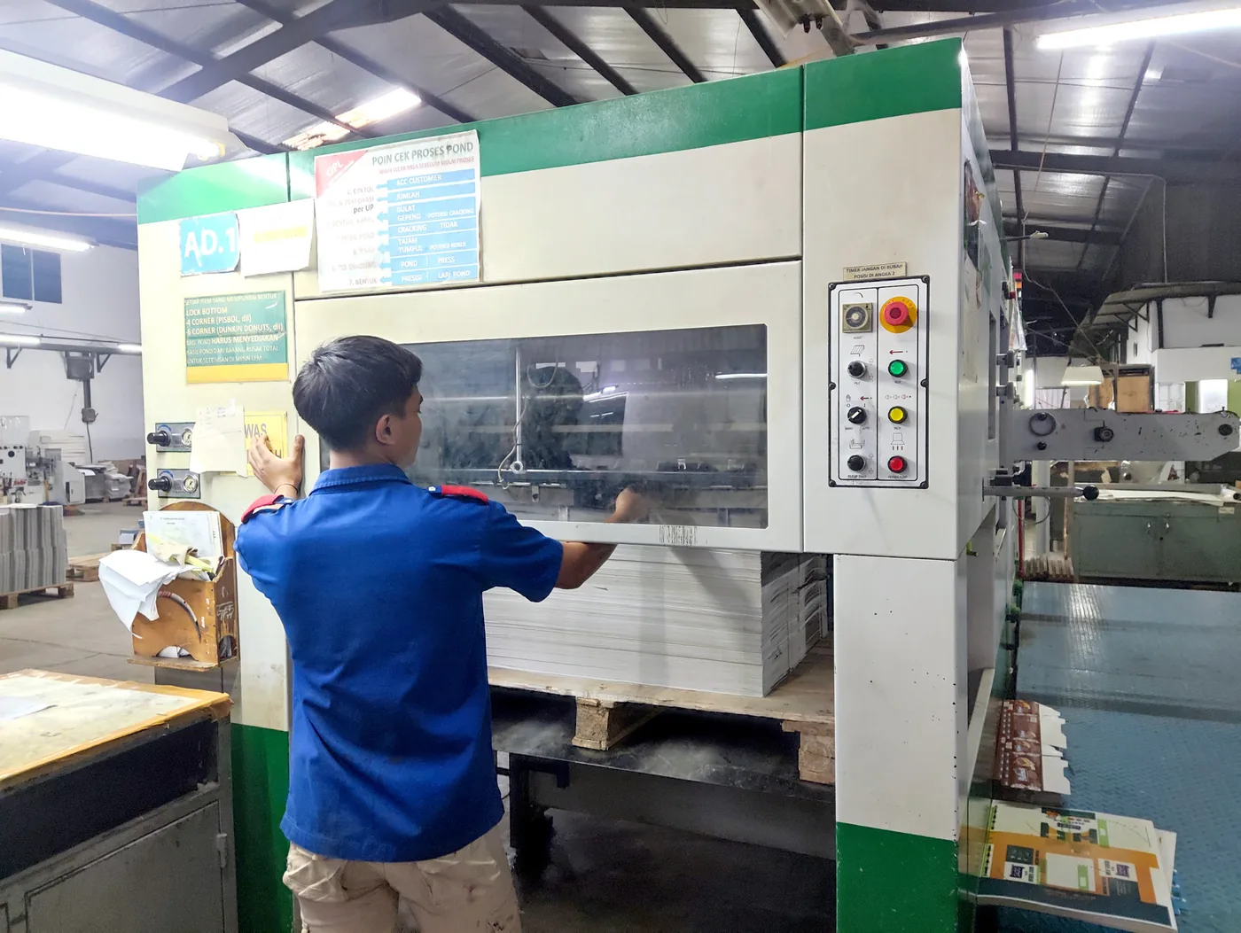 An operator working with post-press equipment